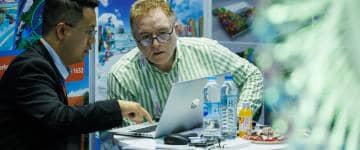 Two men sitting at a table discussing a product