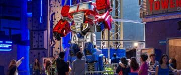 Guests point and look at Optimus Prime Tower ride inside Hasbro City