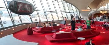 The Sunken Lounge at the TWA Hotel sports a retro look. Visitors can enjoy 1960s cocktail favorites and look out the windows to see the 1958 "Connie" plane.