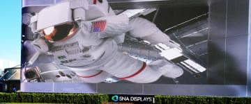 A massive LED screen built at the entrance of the Kennedy Space Center Visitor Complex, showing 3D animations of an astronaut reaching toward the screen