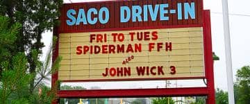 Movie theater marquee sign for Saco Drive-In, located in Maine. Marquee sign text: Fri to Tues, Spiderman FFH and John Wick 3