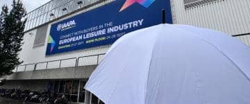 An umbrella shields an attendee at IAAPA Expo Europe