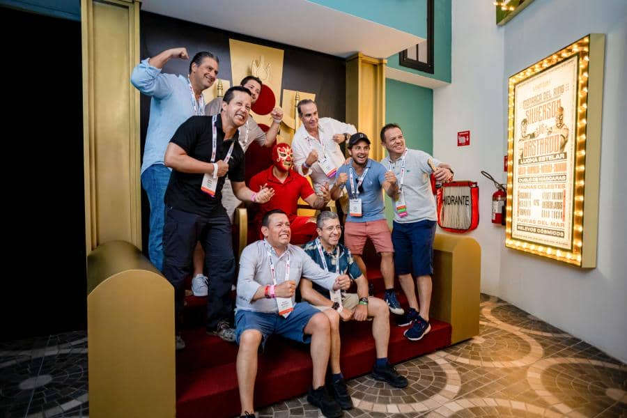 Group photo of IAAPA Latin America and Caribbean members posing in front of a luchador wrestler statue