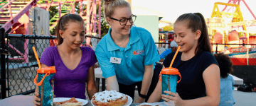 Employee talks to two young guests 